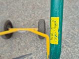 a close up of a green bike with a yellow sticker on it