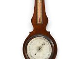 une vieille horloge murale en bois dont le cadran comporte un thermomètre