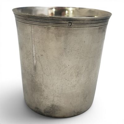 une vieille coupe en argent munie d'une anse, sur fond blanc