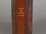 an old brown book sitting on top of a table next to a gray wall