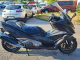 une moto noire garée sur un parking à côté de voitures