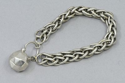 un gros plan d'un bracelet en argent orné d'une clochette