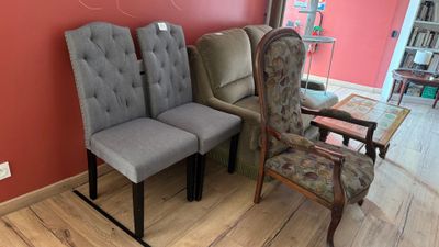 Dans une pièce, plusieurs chaises sont alignées contre un mur rouge.