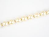 gros plan d'un collier de perles sur une surface blanche