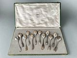 six spoons in a case on a table