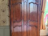 une grande armoire en bois dans le coin d'une pièce