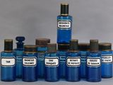 several blue glass bottles with labels on them sitting on a table