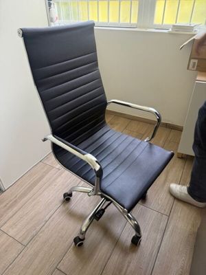 une chaise de bureau noire dans un coin de la pièce