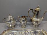 a silver tray with a silver tea set on top of it