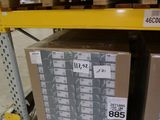 Les cartons sont empilés sur des palettes dans un entrepôt et sont munis d'une étiquette de prix.