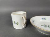 two cups and saucers are sitting side by side on a table
