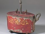 an old red and gold covered box with two birds on it