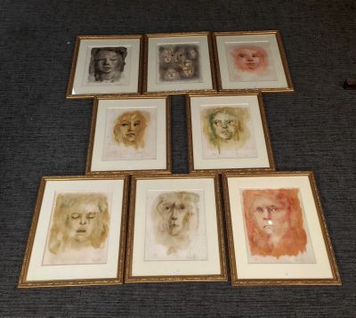 Plusieurs portraits encadrés sont exposés sur un tapis bleu