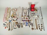 many different types of necklaces and bracelets laid out on a table