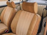 a car that has a tan leather seat cover on it