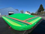 un grand bateau pneumatique posé à terre sur un parking