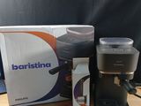 a coffee maker sitting on a table next to a box