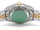 a close up of a wrist watch with a green dial