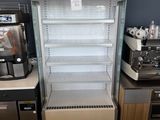 un réfrigérateur situé à côté d'un plan de travail sur lequel se trouve une machine à café