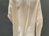 a mannequin wearing a white shirt and white pants on display