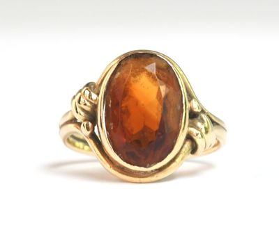 une image représentant une bague en or sertie d'une pierre orange