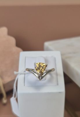 a yellow diamond ring in a white box on a table