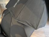 un parapluie noir posé par terre à côté d'une valise
