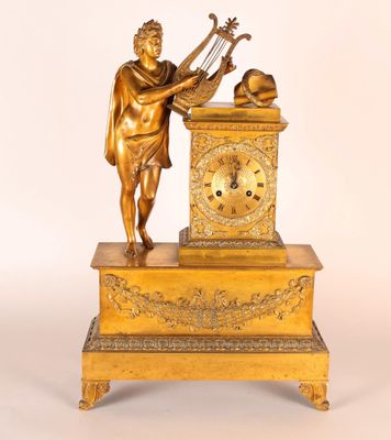une statue représentant un homme jouant d'un instrument de musique à côté d'une horloge