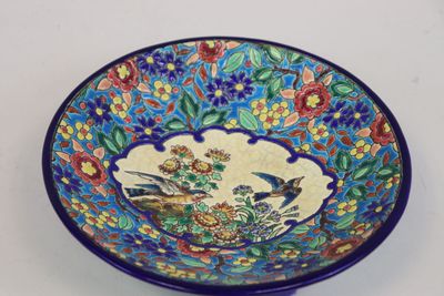 un bol bleu orné d'un motif représentant un oiseau et des fleurs