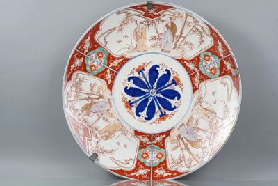 une assiette orange et blanche ornée d'une fleur bleue