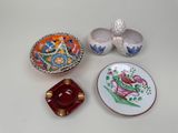 three small dishes and a bowl are sitting on a table