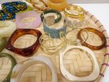 a tray with many different colored bangles and bracelets on it