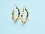 a pair of gold hoop earrings on a white background