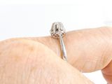 a person holding a silver ring with a diamond on it