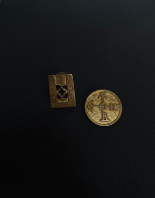a close up of a coin and a small metal object on a black surface