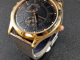 a gold and black watch on a black surface