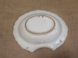 a white plate with a brown rim sitting on a table