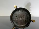 brass clock on a table with a shadow of a man