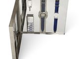 une boîte en métal contenant une montre et un stylo