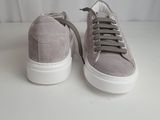 grey sued sneakers with white soles and laces on a white surface