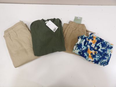 three pairs of men ' s pants on a table with a price tag