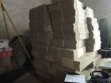 a pile of cardboard stacked on top of each other in a room