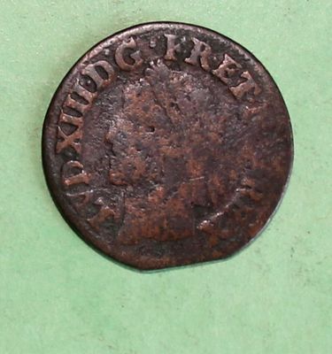 a close up of an old coin on a green surface