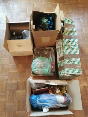 Plusieurs cartons contenant des objets divers sont posés sur un plancher en bois