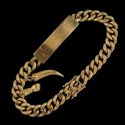 gros plan d'un bracelet en or sur fond noir