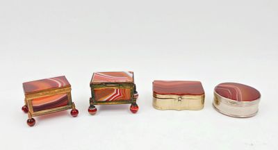 trois boîtes miniatures sont alignées sur une surface blanche