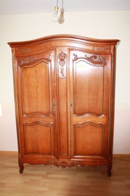 a large wooden armoire in the corner of a room