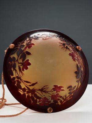 une assiette marron ornée d'un motif floral, posée sur une table