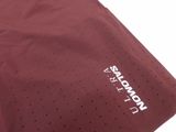 the back of a maroon shirt with a white logo on it