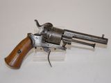 an old revolver with a wooden handle on a white surface